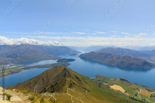 The view from the summit of Roys Peak over Lake Wanaka and the mountains of the Southern Alps as clouds roll over them.
