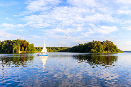 Sailing boat on lake Nidzkie in Ruciane-Nida at sunset time, Mazury Lake District, Poland