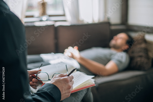 Psychotherapist and patient at an appointment in the office. Doctor's hands with notepad