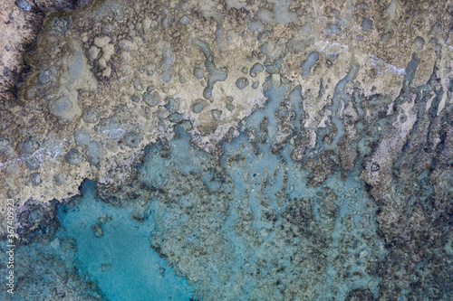 An aerial view of the beautiful Mediterranean sea, where you can see the rocky textured underwater corals and the clean turquoise water of Cyprus