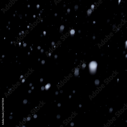 first snow in winter on black sky background, abstract blurred photo