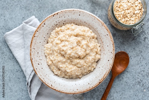 Plain oatmeal porridge in bowl. Healthy vegan vegetarian breakfast food, whole grain porridge oats