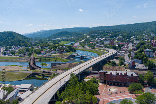 Interstate 68 passes through Cumberland, Allegany County, Maryland. A railroad bridge on the left crosses the Potomac River to Ridgeley, West Virginia.