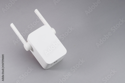 White Wireless WiFi repeater on gray background.
