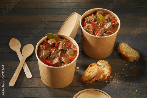 Two unlabelled takeaway tubs of rich beef goulash