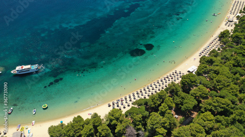 Aerial drone photo of beautiful popular organised sandy bay, turquoise beach and natural preserve lake with pine trees of Koukounaries, Skiathos island, Sporades, Greece