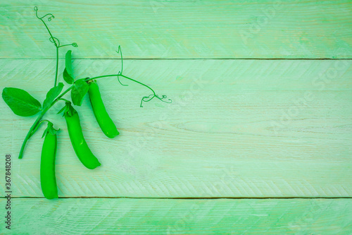 Fresh green pease from the garden on a wooden background