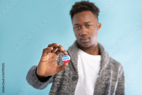 Vote button in hand of african american voter