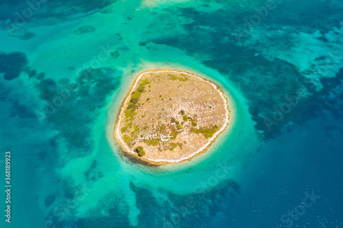Adriatic sea in Croatia, lone island of Ricul in turquoise sea in Murter archipelago, aerial view of from drone