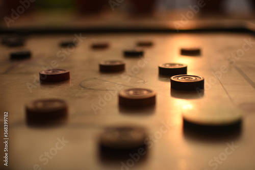 The game of carroms being played at the evening in the home. 