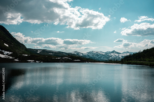 Natural scandinavian beautiful landscape. Glacial lake, fiord, snowy mountains. Sunny day in nortnern Norway. 