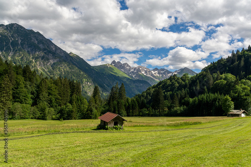 Hut on a meadow in front of snowcapped mountains, Ällgäu, Germany