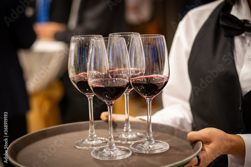 waiter serving glass of red wine