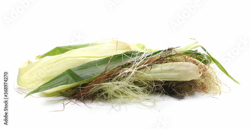 Corncob, maize husks and stringy corn silk pile isolated on white background