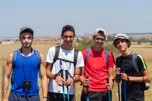 four young people with trekking poles and binoculars doing the Camino de Santiago in Spain
