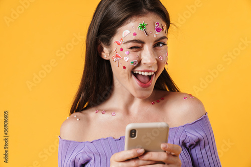 Image of nice cheerful woman using cellphone and winking