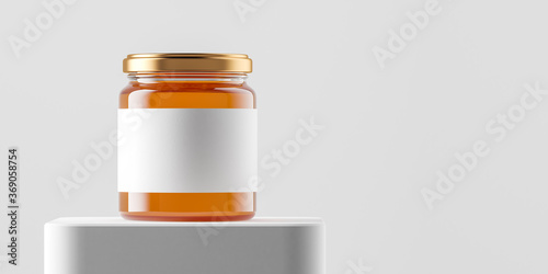 Transparent glass jar with copper metal cap and blank label filled by sweet honey on the podium over white background.