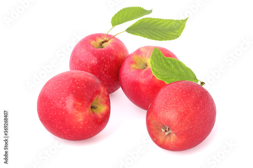 Four tasty red apples with leaves isolated on white