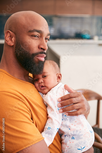 Smiling Stay At Home African American Father Cuddling And Playing With Baby Daughter Indoors At Home