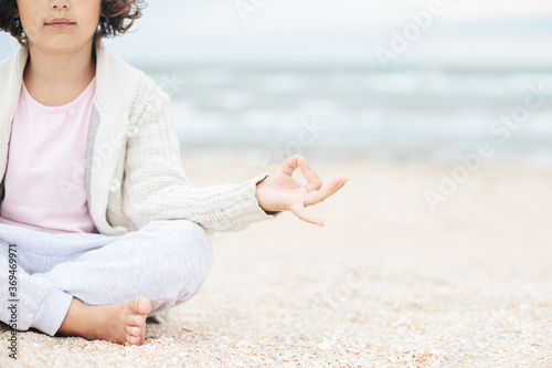 little girl meditating on the beach