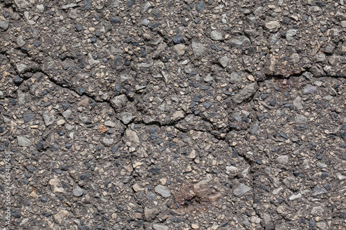 Spękana asfaltowa nawierzchnia drogi.