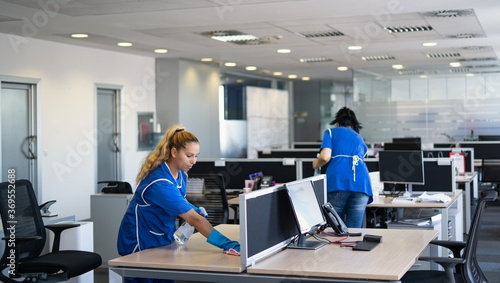 Cleaners clean empty office spaces