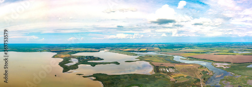 the confluence of the Pravyi Beisuzhek and Beysug rivers in the Lebyazhy estuary (South of Russia, Krasnodar Territory) near the village of Bryukhovetskaya, surrounded by flat fields - aerial pano 