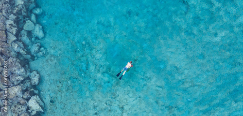 An aerial view of the beautiful Mediterranean Sea and a swimmer, where you can see the cracked rocky textured underwater corals and the clean turquoise water of Protaras, Cyprus, 