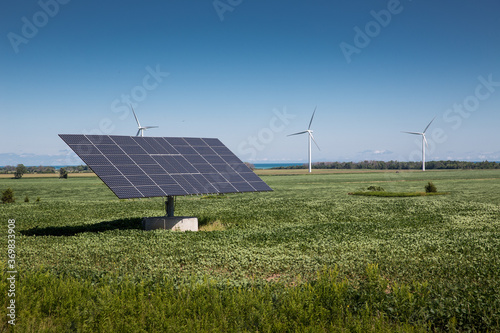 Clean green renewable energy at work in a field of wind turbines and solar panels in Ontario Canada