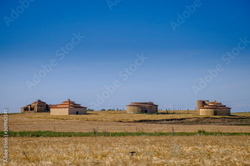 Old buildings used as dovecotes in the rural area with wheat cultivation land in the interior of Spain.