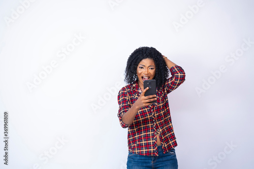 young black woman looking at her phone feeling worried