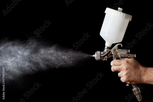 Close up of a spray paint gun with black background