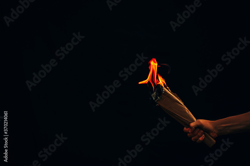 Man hand holding white burned paper. Fire. Dark background. Man hand. Male. 
