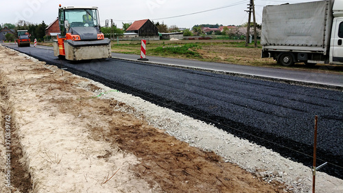 Zagęszczanie ułożonej warstwy bitumicznej na drodze.