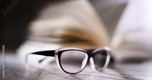 Composition with glasses and open book on the table