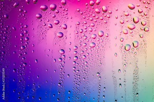 Water droplets on glass surface. Colorful blurred abstract of water drops texture on pink magenta background
