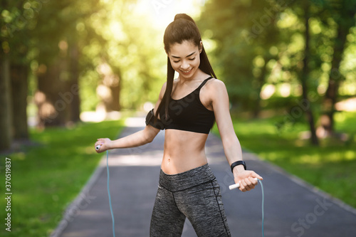 Fit Korean Girl Training With Jump Rope In Park, Enjoying Exercising Outdoors