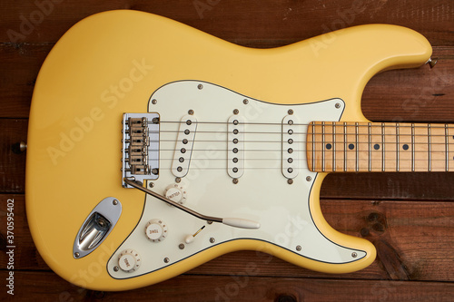 Butter colored Strat guitar on dark table