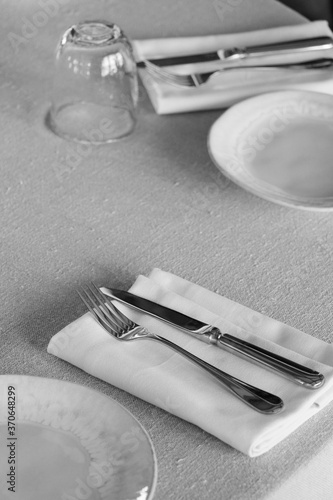 restaurant cutlery, knife and fork on a table with napkin