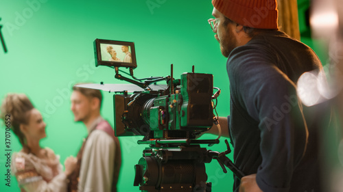 Portrait of Cameraman on Railway Trolley Shooting Green Screne Scene. Professional Crew on Big Budget Filmmaking. On Film Studio Set Shooting Historical Movie Green Screen Scene.