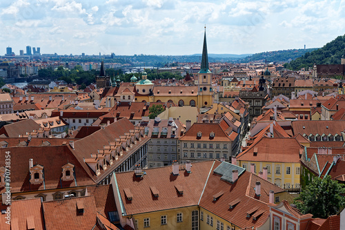 view of St. Thomas church and the red roofs of prague from castle