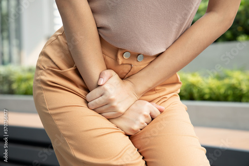 woman holding her pee, health care concept of urinary tract infection; urinary incontinence; overactive bladder symptoms