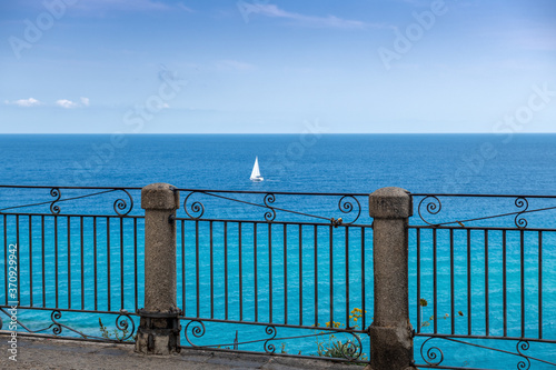 Widok z tarasu w Tropea na samotny jacht na morzu