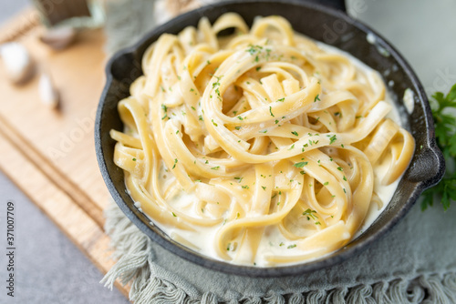 Alfredo pasta dinner with creamy white sauce and herbs