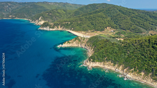 Aerial drone photo of paradise emerald and turquoise sandy beach of Aselinos covered in pine trees in island of Skiathos, Sporades, Greece