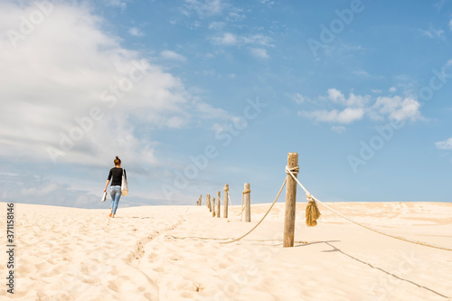 Barefoot woman walking on the sand dunes in the Slowinski National Park in Leba, Poland