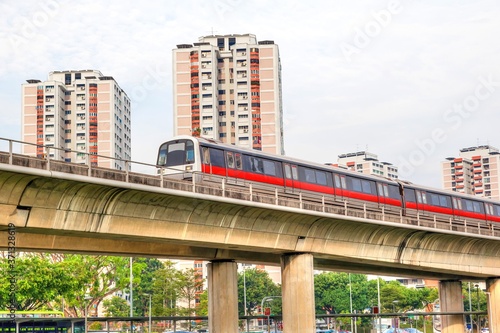 Singapore subway train on elevated tracks through a public housing estate