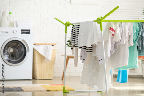 Clean clothes hanging on dryer in laundry room