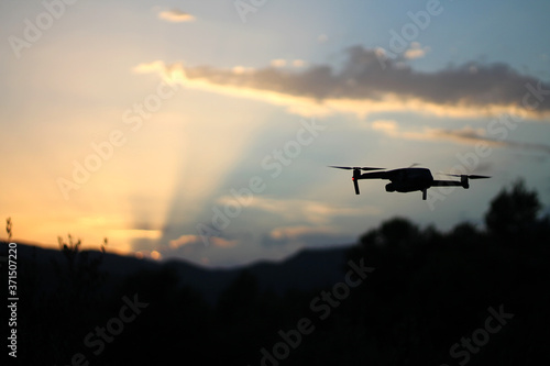 stock photo of drone flying at sunset on the mountain