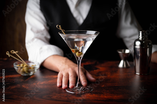 bartender serving martini in glass at bar